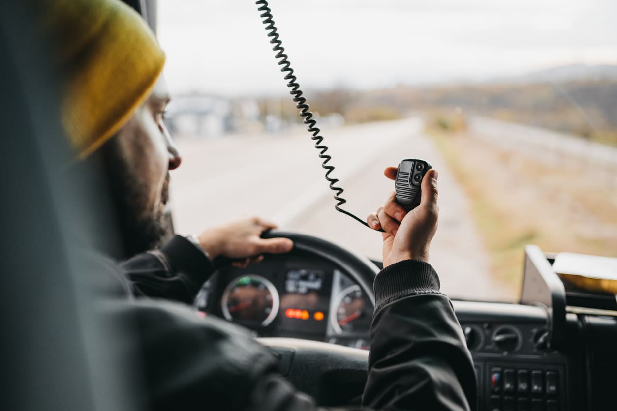 guy in yellow hat holding truck radio