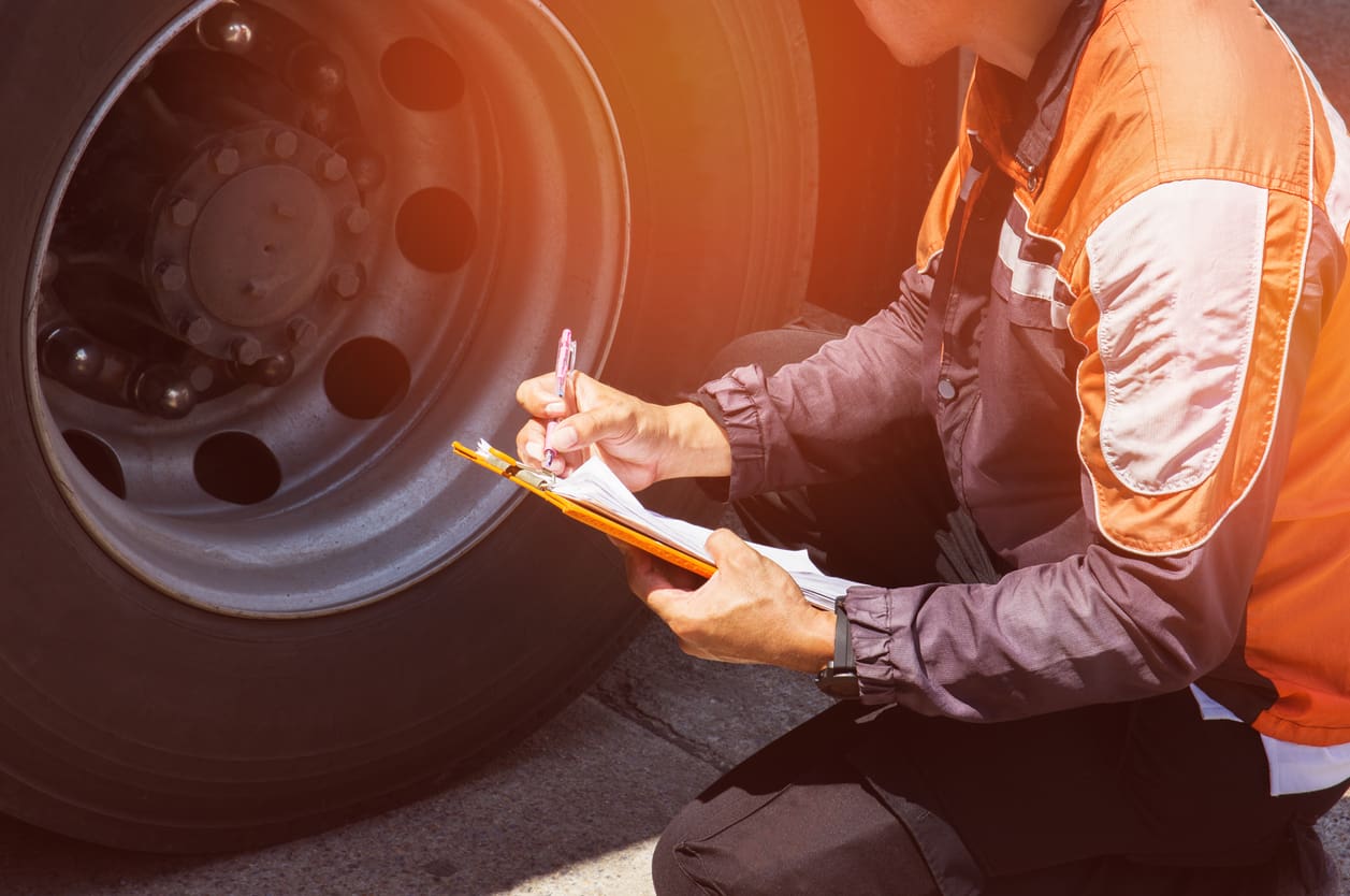 Truck driver is inspecting a truck tires