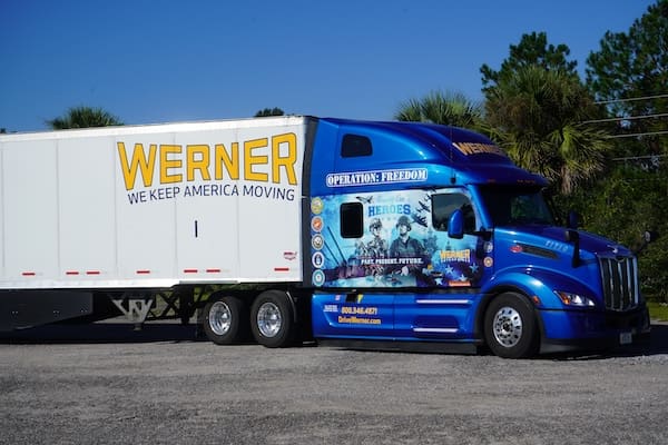 A photo of a commercial truck with the Werner company logo on it and a picture of military members under the headline Operation: Freedom.
