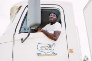 A person who couldn't find a job after a layoff once they become a truck driver, happily driving their truck