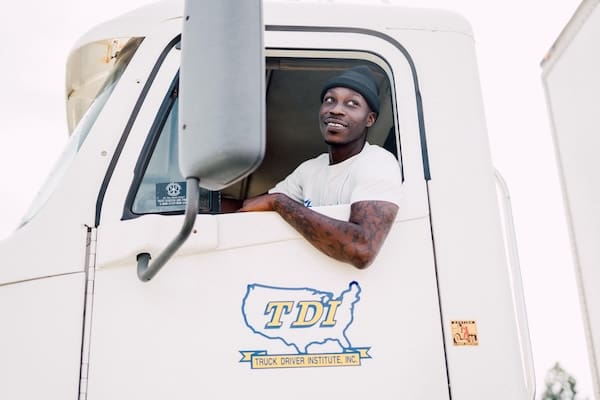 A person who couldn't find a job after a layoff once they become a truck driver, happily driving their truck