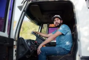 A truck driver parked and looking hopefully outside where he can encounter the best discounts for truckers