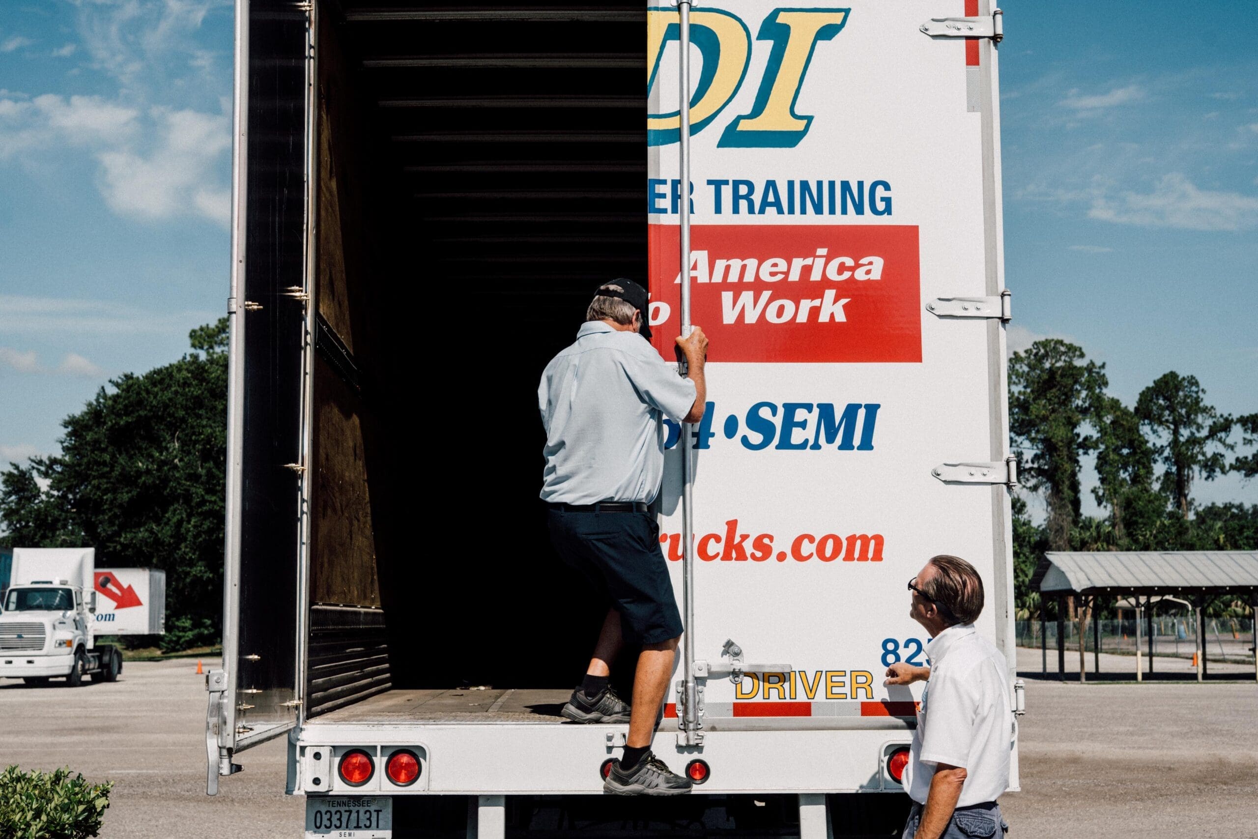Two truck drivers working on a truck.